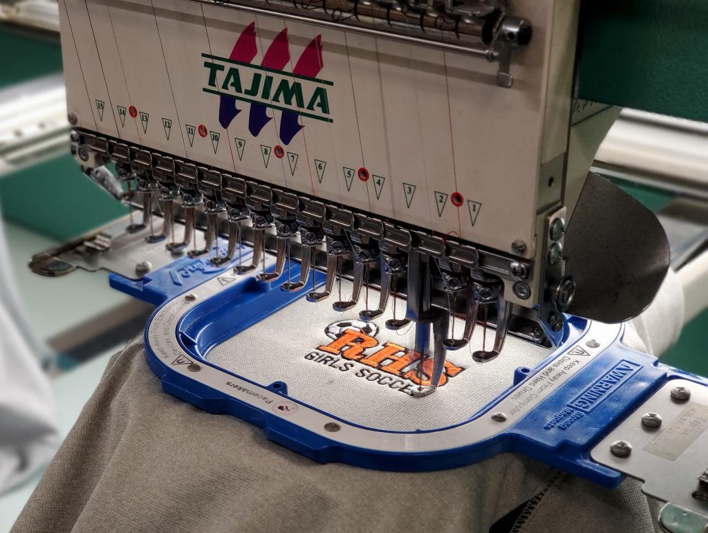 A machine is being used to embroider clothes.